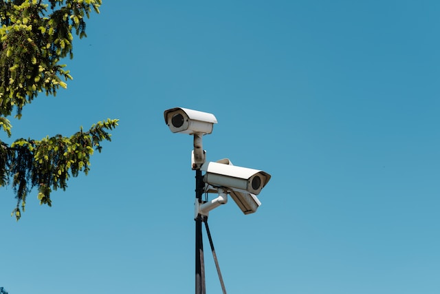 photo of two white security cameras on a poll in daylight