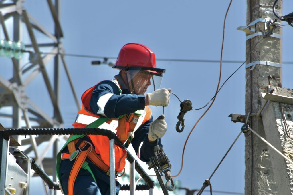 photo of a worker in an aerial lift holding wires