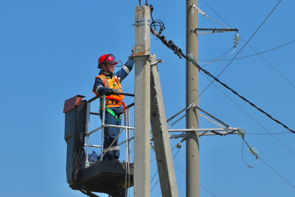 photo of worker in an aerial lift fixing wires