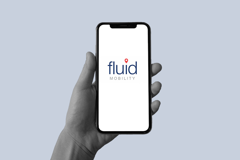 hand holding a phone that has the fluid mobility logo on it